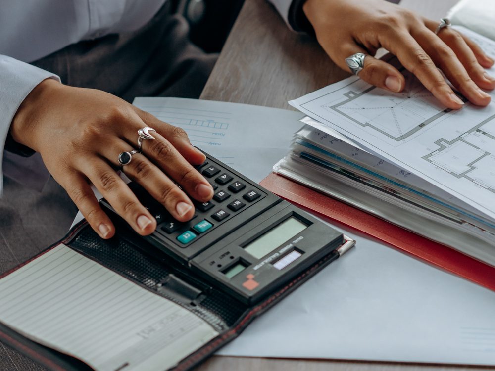 Investor calculating purchase and works costs against floor plans for a below market value property