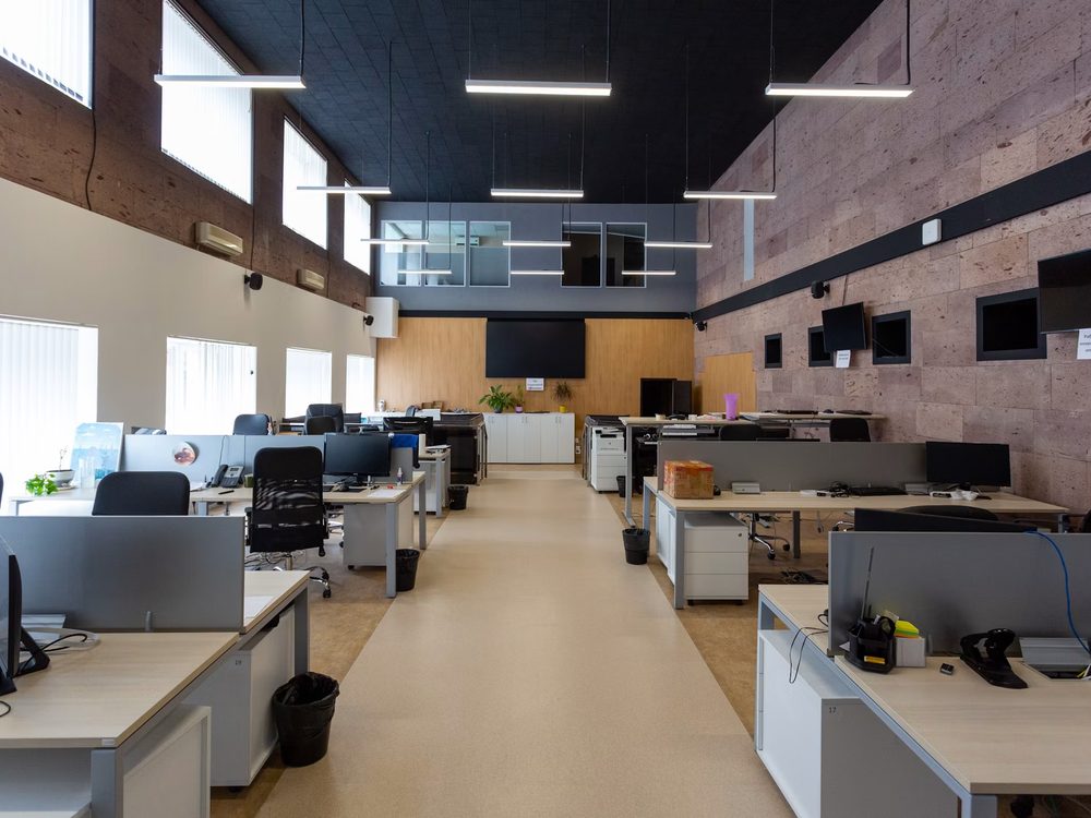 Deep open-plan office floor with windows on one side only, a natural light challenge for a residential conversion