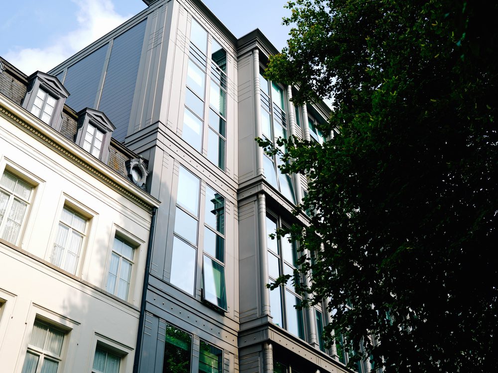 Modern residential facade beside a period building, the kind of finished scheme a conversion exit depends on
