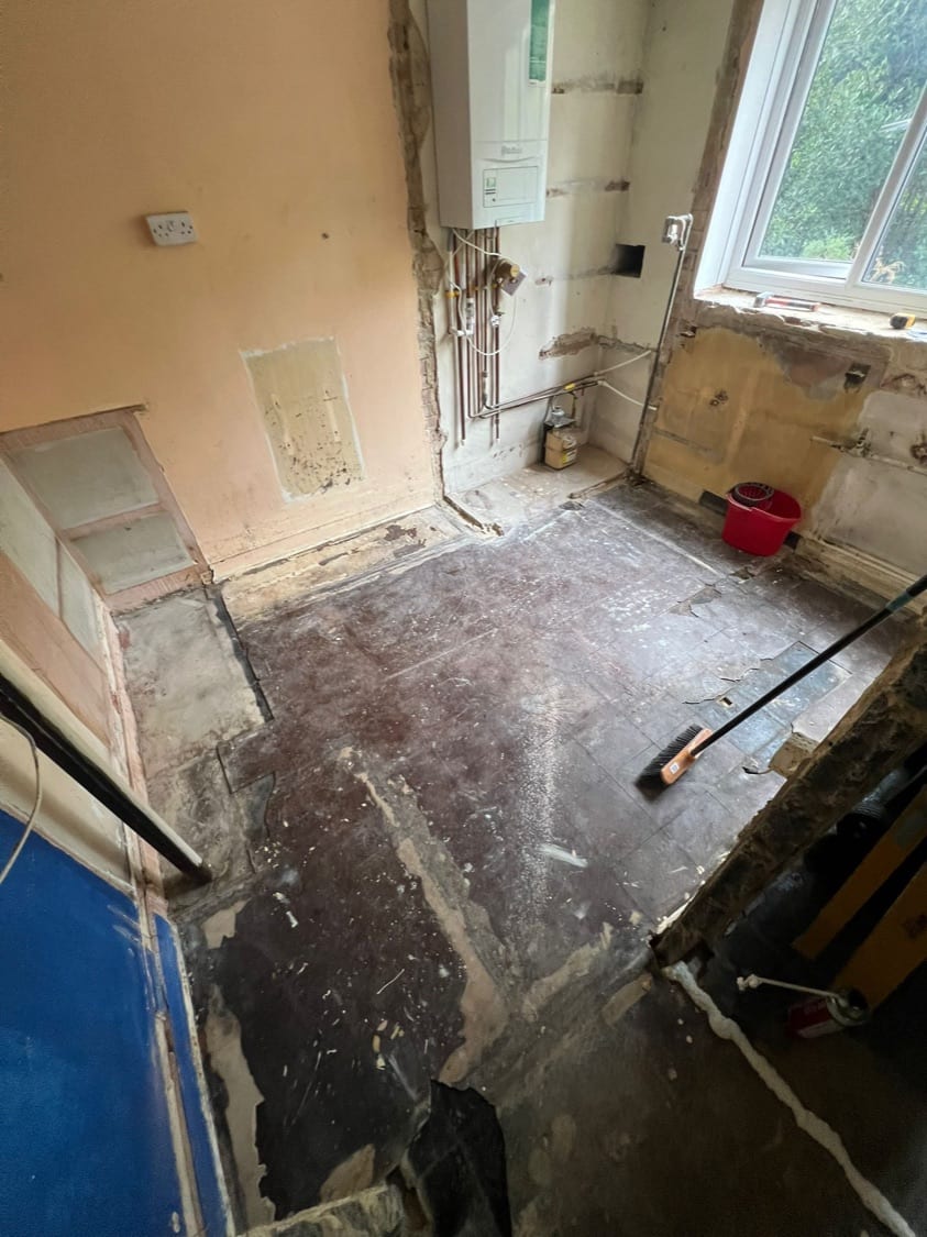 Kitchen stripped to the original floor tiles and boiler pipework at the Innes Gardens flat