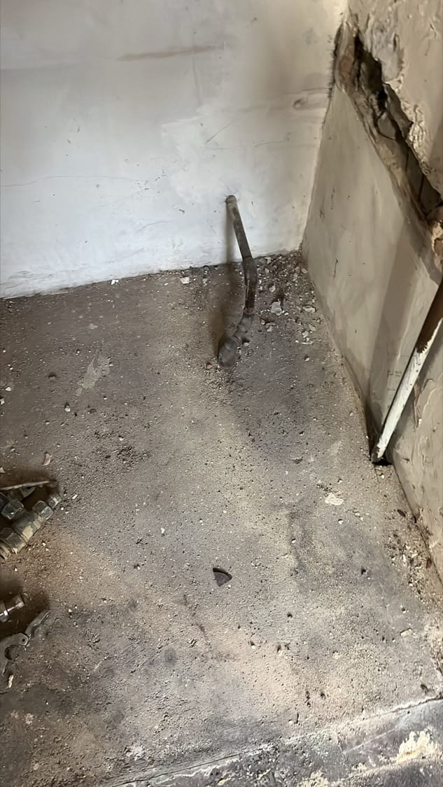 Old pipe stub exposed in a cut brick wall opening during strip-out at the Innes Gardens flat