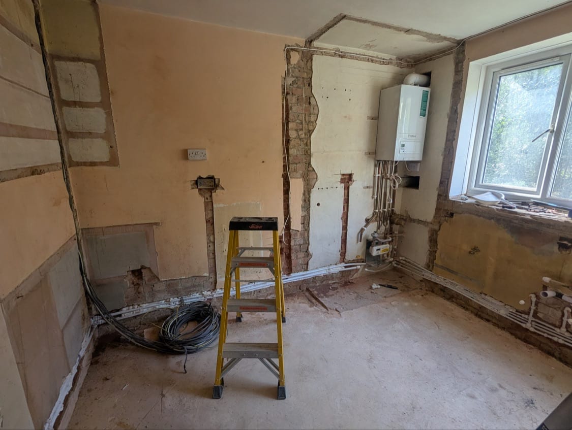 Kitchen wall with channels chased for electrics near the relocated boiler position at the Innes Gardens flat